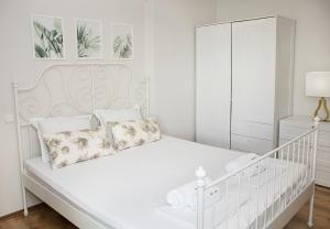 a white bedroom with a white bed and a white cabinet at Cozy Seaside Escape - Stylish 1-Bedroom Apartment in Central Balchik by Flat Mаnager in Balchik