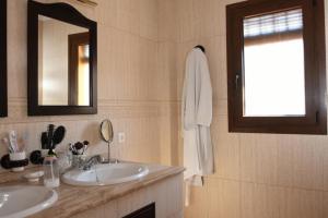 a bathroom with two sinks and a mirror and a window at CasaBlancaflor in Peñaflor