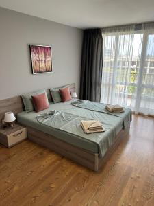 Un dormitorio con una cama grande en una habitación con ventanas. en Sunset, en Chernomorets