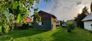 een huis in een tuin met een grasveld bij Domek Letniskowy Łętowo in Łętowo