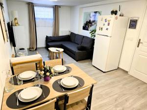 kuchnia i salon ze stołem i lodówką w obiekcie Appartement T2 confortable - Piscine et Jacuzzi w mieście Pierrelaye