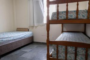 Un dormitorio con dos literas y una ventana. en Otimo apartamento a 200m do mar com WiFi, en Campo Grande