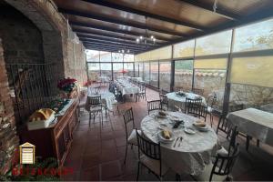 a dining room with tables and chairs and windows at Hotel Casa Rural Betancourt in Almadén