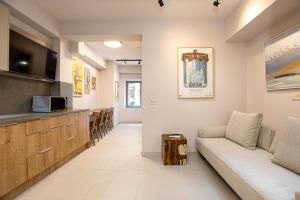 a living room with a couch and a tv at DUENDE Residence in Rethymno Town