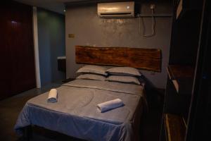 a bed in a room with two towels on it at Pondok Beach Shack in Tioman Island