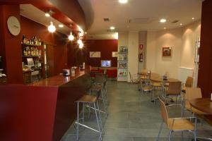 um restaurante com mesas e cadeiras e um bar em AB Murias Blancas em Villaviciosa