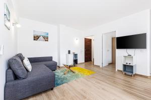 een woonkamer met een bank en een flatscreen-tv bij Côte et mer - BY BEDZY in Carvoeiro