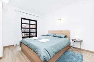 een slaapkamer met een groot bed met blauwe lakens bij Côte et mer - BY BEDZY in Carvoeiro