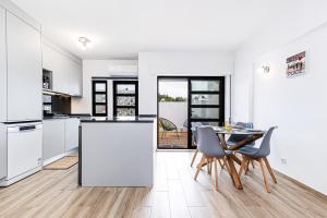 een keuken en eetkamer met een tafel en stoelen bij Côte et mer - BY BEDZY in Carvoeiro