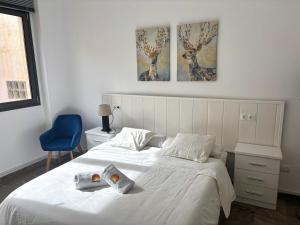 Una cama blanca con dos toallas encima. en Apartamento Antonio By Solymar Holiday, en Torre del Mar