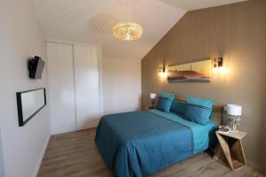 a bedroom with a blue bed and a chandelier at Kurutxiaitako borda in Lasse +29 photos