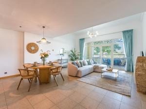 una sala de estar con un sofá y una mesa en Beachfront Sea View 1BR-Jash Falqa- Palm Jumeirah, en Dubái