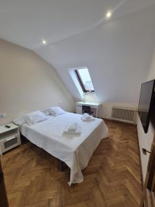 a bedroom with a large white bed in a attic at Alfonso X Lucus Confort in Lugo +20 photos