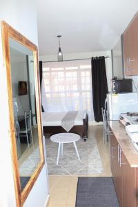 a kitchen with a mirror and a table in a room at Affordable Luxury Ruaka in Ruaka