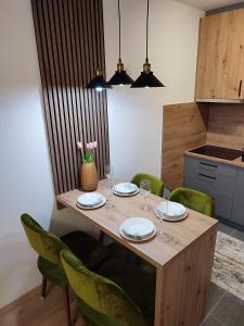 a wooden table with plates and wine glasses on it at Stan na dan Paradiso in Lukavica