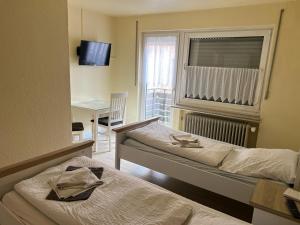 a room with two beds and a table and a window at Ferienwohnung mit 4 Betten - Balkon - Küche in Fuldabrück