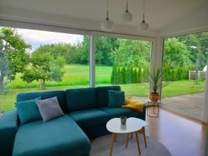 a living room with a blue couch and a large window at Ferienwohnung "Auszeit im Grünen" in Bad Schussenried