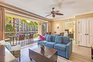 a living room with a couch and a table at Honua Kai Hokulani 214 in Lahaina