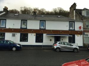 un edificio con dos coches estacionados frente a él en The Anchor Inn, en Garelochhead