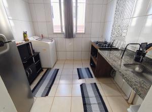 a small kitchen with a sink and a washing machine at Apartamento Tranquilidade! in Uberaba