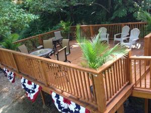 a wooden deck with chairs and tables and plants at Brownstone Rose Suite Parking Walk to Dwntn in Eureka Springs +21 photos