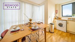 un salon avec une table et une cuisine dans l'établissement Premium Serviced Apartment in Basingstoke Town Centre, Free Parking By Redwood Stays, à Basingstoke