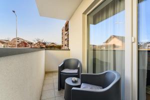 a balcony with two chairs and a table at Blue Moon Apartments in Braşov