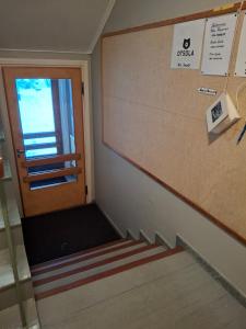escalera en una habitación con puerta y ventana en Tuulanmajoitus, en Mänttä