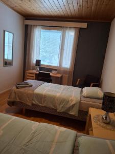 Un dormitorio con dos camas y una ventana. en Tuulanmajoitus, en Mänttä 6 fotos más