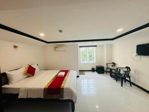 a bedroom with a bed and a table and a television at Cường Thịnh Hotel in Ho Chi Minh City