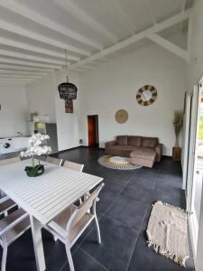 a living room with a white table and a couch at Villa moderne avec piscine à Sainte-Rose, 160 m² in Sainte-Rose