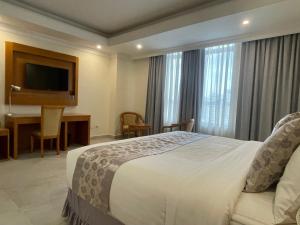 a hotel room with a bed and a desk and a table at Amran hotel in Addis Ababa