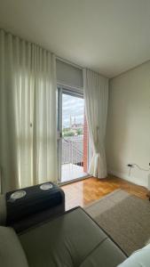 a room with a bed and a large window at Apto Charmoso Próximo à Catedral in Santa Cruz do Sul