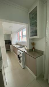 a kitchen with a washing machine on a counter at Apto Charmoso Próximo à Catedral in Santa Cruz do Sul