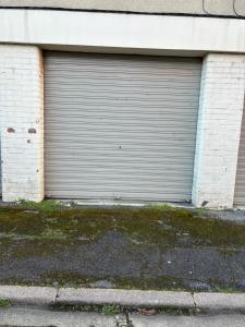 a closed garage door on the side of a building at Appartement de Adrien Garage privé in Charleville-Mézières