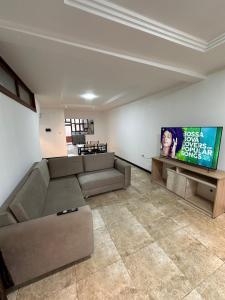 un salon avec un canapé et une télévision à écran plat dans l'établissement Departamento Familiar Cómodo Cerca de el Centro, à Cuenca