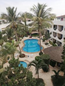 an aerial view of a resort with a pool and palm trees at Studio Samba in Saly Portudal