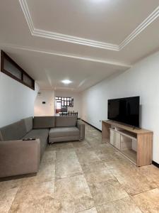 un salon avec un canapé et une télévision à écran plat dans l'établissement Departamento Familiar Cómodo Cerca de el Centro, à Cuenca 11 autres photos