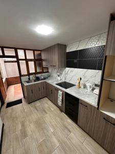 une cuisine avec un évier et un plan de travail dans l'établissement Departamento Familiar Cómodo Cerca de el Centro, à Cuenca