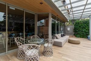 a patio with a couch and a table and chairs at Studio de luxo e Sofisticado no Moinhos LBO203 in Auxiliadora