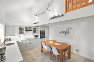 a kitchen with a wooden table and white cabinets at Stunning 3 Bed Barn close to Bigbury on Sea in Bigbury on Sea
