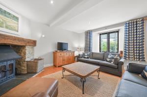 a living room with a couch and a fireplace at Stunning 3 Bed Barn close to Bigbury on Sea in Bigbury on Sea