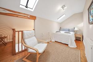 a bedroom with a bed and a chair in it at Stunning 3 Bed Barn close to Bigbury on Sea in Bigbury on Sea
