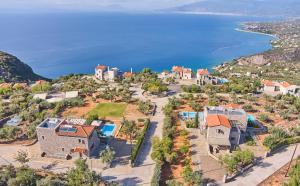 an aerial view of a house on a hill next to the water at Searocks Exclusive Village in Kalamata