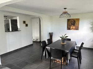 Un comedor con una mesa y sillas negras. en Maison spacieuse avec piscine à Sainte-Anne, 250 m², en Sainte-Anne