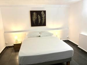 Un dormitorio con una cama blanca con dos almohadas. en Maison spacieuse avec piscine à Sainte-Anne, 250 m², en Sainte-Anne 26 fotos más