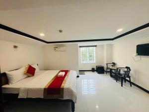 a bedroom with a bed and a table and a television at Cường Thịnh Hotel in Ho Chi Minh City +35 photos