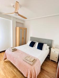 a bedroom with a large white bed with blue pillows at Apartamento Costa del Sol Suances in Suances +14 photos