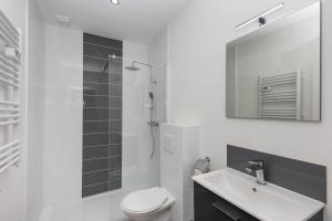 een badkamer met een toilet, een wastafel en een spiegel bij T3 Le Foudroyant in Brest