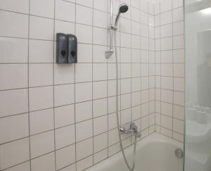 a bathroom with a shower with a phone on the wall at Downtown Bliss Modern Retreat with FREE parking and FAST Internet 600 MBits in Vienna +19 photos